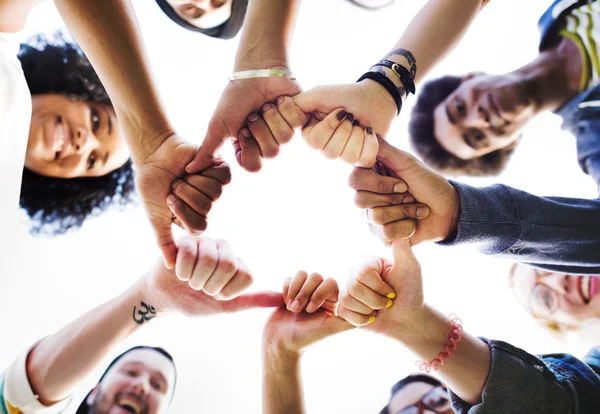 a group of people holding their hands together